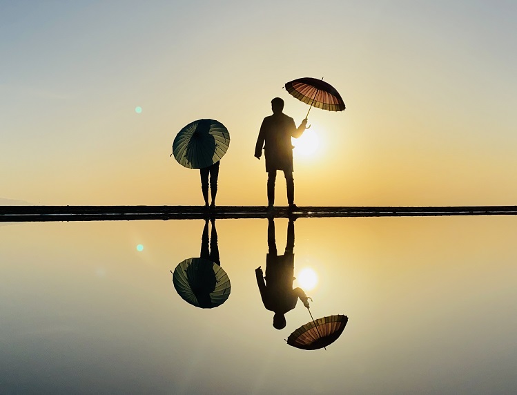夕日と傘を持つ写真父母ヶ浜