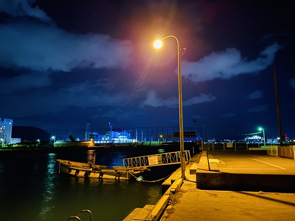 オレンジの照明のある満潮時の漁港の防波堤