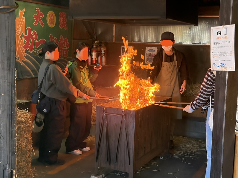 串に刺さった生カツオ火が燃え上がる
